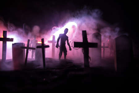 Scary view of zombies at cemetery dead tree, moon, church and spooky cloudy sky with fog, Horror...