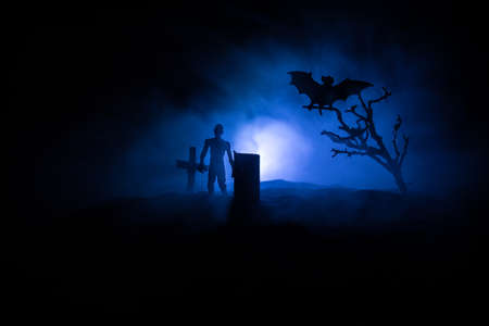 Scary view of zombies at cemetery dead tree, bat and spooky cloudy sky with fog, Horror Halloween...