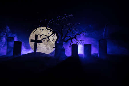 Scary view of zombies at cemetery dead tree, moon, church and spooky cloudy sky with fog, Horror...