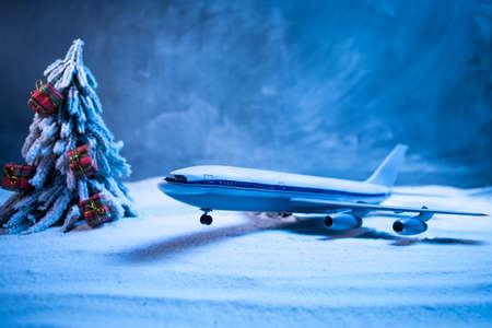Merry Christmas and Happy new years travel concept background for winter trip. Christmas background with airplane. Creative artwork decoration on snow. Selective focus.の写真素材