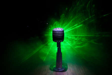 Retro style microphone on background with backlight. Vintage silver Microphone for sound, music,...