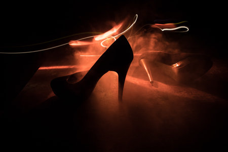 Artwork decoration. Silhouette of a high heel women shoes at dark. Women power or women domination concept. Selective focusの写真素材