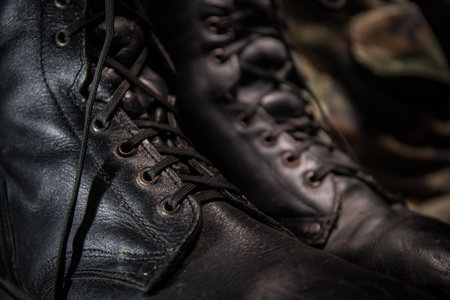 War concept. Old military shoe in a dark toned foggy background. Creative concept of military aggression. Selective focusの写真素材