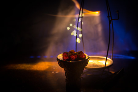Close-up of burning charcoal cubes. Action. Cubes of embers burning in bowl for smoking hookah. Creative artwork decoration on dark background. Empty space. Selective focusの写真素材