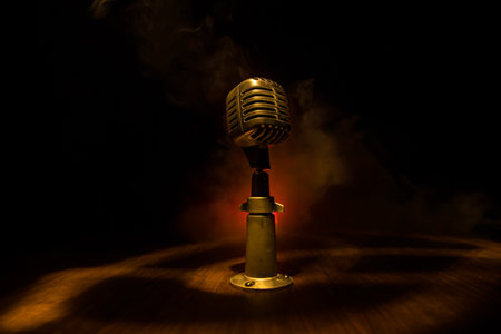 Retro style microphone on background with backlight. Vintage silver Microphone for sound, music, karaoke. Speech broadcast equipment. Live pop, rock musical performance. Selective focusの写真素材