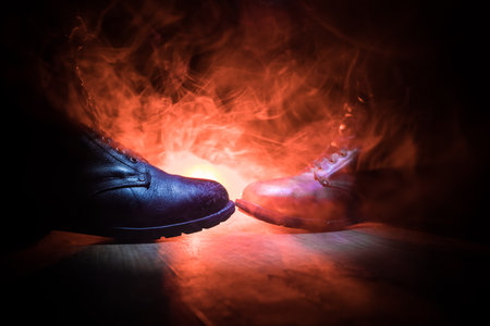 War concept. Old military shoe in a dark toned foggy background. Creative concept of conflict between countries, military aggression. Selective focusの写真素材