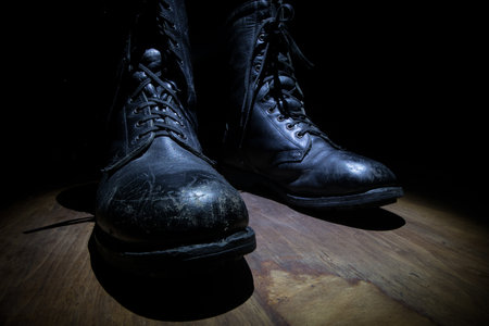 War concept. Old military shoe in a dark toned foggy background. Creative concept of military aggression. Selective focusの写真素材