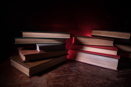 A stack of old books. Vintage book on wooden table. Magic lightning around a glowing book in the...