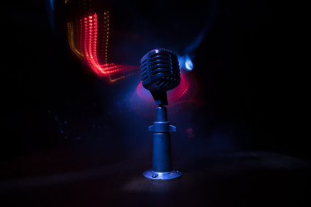 Retro style microphone on background with backlight. Vintage silver Microphone for sound, music,...