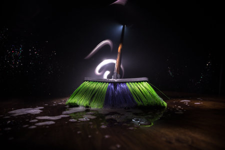 close-up brush the floor on a dark background with light and fog. Broom in dark. Cleaning concept. Selective focusの写真素材