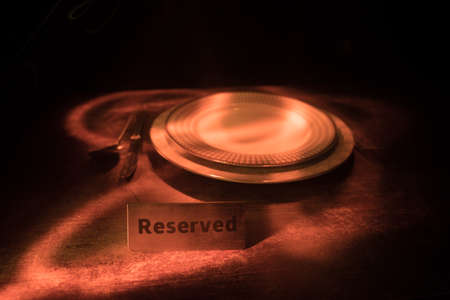 Reserved sign on the table. A tag of reservation placed on the wood table. Metal tag with...