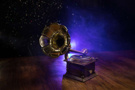 Music concept. Old gramophone on a dark background. Retro gramophone with disc on wooden table with...