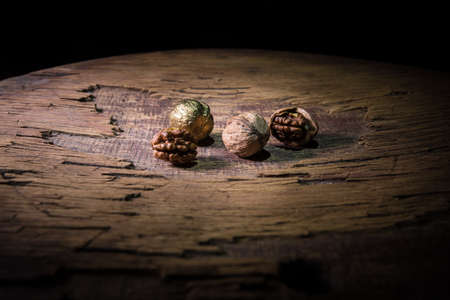 Nut meal concept. Still life with Walnut kernels and whole walnuts on rustic old wooden table....