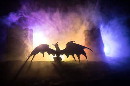 Fantasy battle scene with dragons attacking a medieval castle at night. Battle between dragon and heroic soldiers. Creative table decoration. Selective focusの写真素材