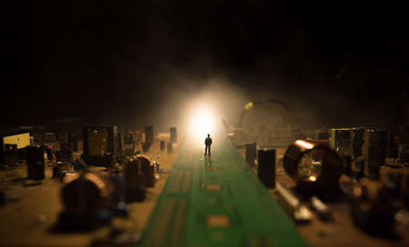 Creative concept of modern technology, inside an electronic device. Man miniature standing on...
