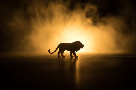 Silhouette of a lion miniature standing on wooden table. Creative decoration with colorful backlight...