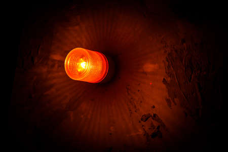 Emergency lighting in the factory, Warning light, Orange siren on concrete wall. Long exposure