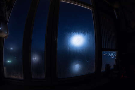 Full moon over the valley in window view. Fisheye lens shot wind angle. Long exposure