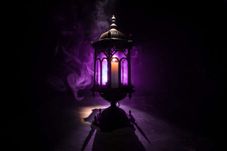 Arabic lantern with candle at night for Islamic holiday. Muslim holy month Ramadan. The end of Eid and Happy New Year. Copy space on dark background.の写真素材