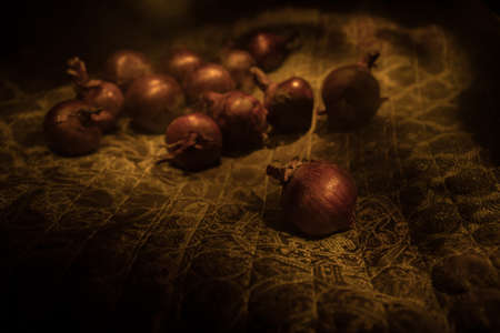 Vegetable concept. Purple onions on carpet surface in dark. Selective focus. Colorful background.の写真素材