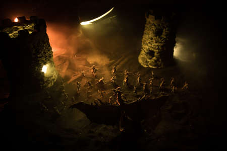 Fantasy battle scene with dragons attacking a medieval castle at night. Battle between dragon and...