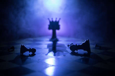 Beautiful crown miniature on chessboard. chess board game concept of business ideas and competition and strategy ideas concept. Chess figures on a dark background with smoke and fog. Selective focusの写真素材