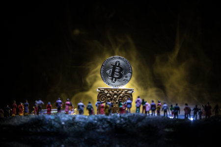 Golden Bitcoin on dark backround. New virtual money. Crypto currency. Crowd miniature looking on Bitcoin in Selective focusの写真素材