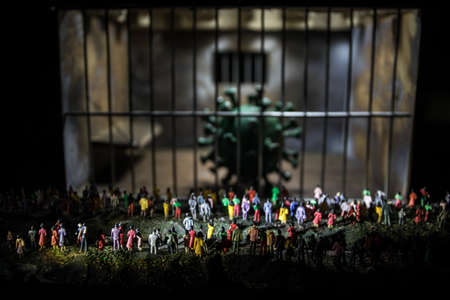 virus lockdown creative concept. Crowd looking on novel miniature inside old prison. Creative artwork decoration. Selective focusの写真素材
