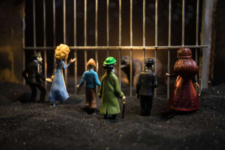 People and animals on opposite sides of the fence concept. Creative decoration with toy figures. Burning colorful background. Selective focus.の写真素材