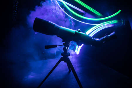Silhouette of a astronomy telescope on dark foggy backlight. Selective focusの写真素材