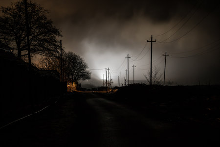 Night street country road with buildings and fences covered in fog lamp. Or Mysterious night in...
