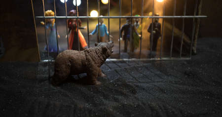 People and animals on opposite sides of the fence concept. Creative decoration with toy figures....