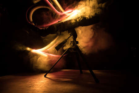 Silhouette of a astronomy telescope on dark foggy backlight. Selective focusの写真素材