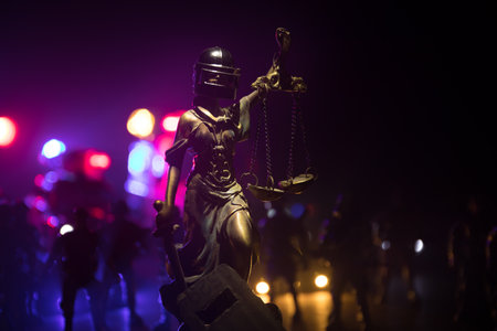 No law or dictatorship concept. The Statue of Justice with anti-riot police helmet holding scale. Creative artwork decoration with colorful toned foggy background. Selective focusの写真素材