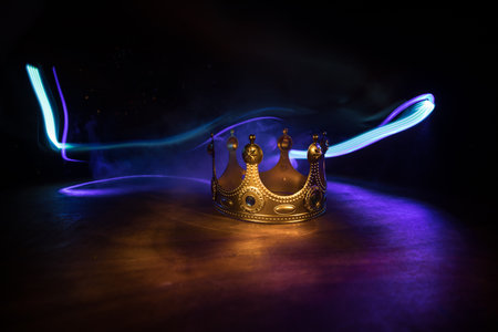 low key image of beautiful queen / king crown over wooden table. vintage filtered. fantasy medieval period. Selective focus. Colorful backlightの写真素材