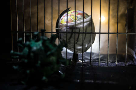 Corona virus lockdown creative concept. Planet earth trapped inside old prison. Creative artwork decoration. Selective focusの写真素材