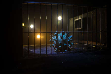 Corona virus lockdown creative concept. Corona virus novel miniature trapped inside old prison. Creative artwork decoration. Selective focusの写真素材