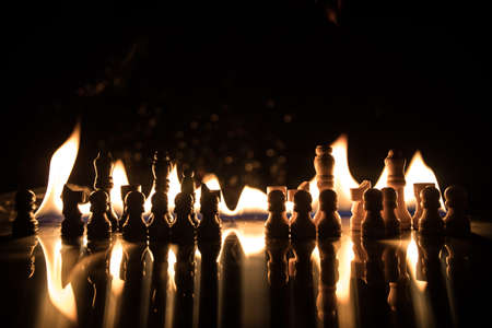? hess pieces on the chessboard against the background of a burning fire. Selective focusの写真素材