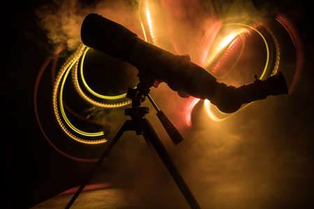 Silhouette of a astronomy telescope on dark foggy backlight. Selective focusの写真素材
