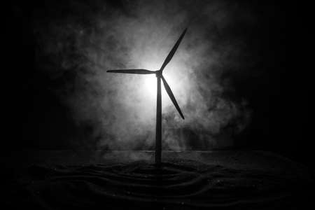 Electricity power in nature or clean energy concept. Wind Turbine producing alternative energy on hill at night. Creative decoration with small miniature. Selective focusの写真素材