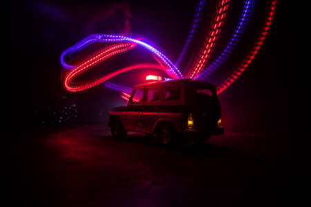 Police car chasing a car at night with fog background. 911 Emergency response police car speeding to scene of crime. Creative decoration. Selective focusの写真素材