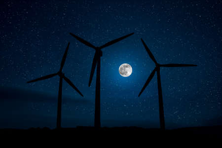 Electricity power in nature or clean energy concept. Wind Turbine producing alternative energy on hill at night. Creative decoration with small miniature. Selective focusの写真素材