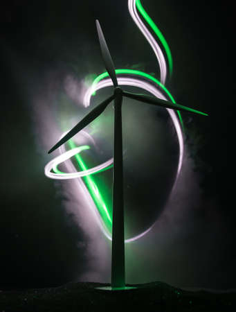 Electricity power in nature or clean energy concept. Wind Turbine producing alternative energy on hill at night. Creative decoration with small miniature. Selective focusの写真素材