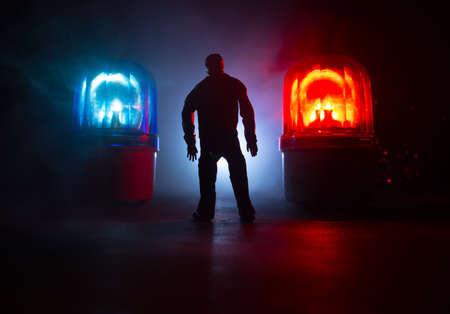 Legal law or crime concept. Man alone standing in the middle of the road on a foggy night. Artwork decoration with handcuffs, Statue of Justice and mallet of justice on toned foggy background.の写真素材
