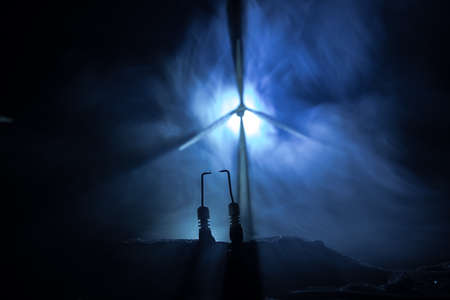 Electricity power in nature or clean energy concept. Wind Turbine producing alternative energy at night time. Creative decoration with small miniature. Selective focusの写真素材