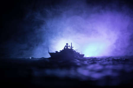 War concept. Night battle scene at sea. Dramatic toned clouds effect. Silhouette of the battle ship...