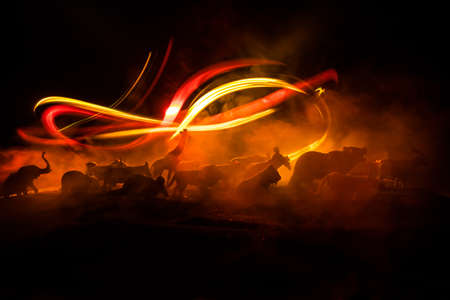 A group of animals are grouped together at foggy night with burning colorful background. Animals Running Escaping to Save Their Lives from fire. Selective focus.の写真素材