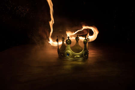 low key image of beautiful queen / king crown over wooden table. vintage filtered. fantasy medieval period. Selective focus. Colorful backlightの写真素材