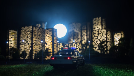 Cartoon style city buildings. Realistic city building miniatures with lights. background. Miniature police standing with City lights on the background. Selective focusの写真素材