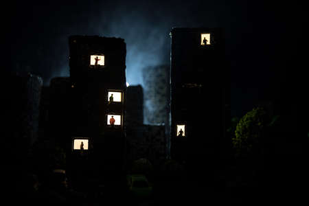 concept of loneliness, in the form of a silhouette of woman and man in a city window at night. Symbol of expectation, dreams and destinies. Creative decoration with City miniature. Selective focusの写真素材